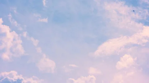 Fluffy clouds illuminated by the sun float beautifully across the clear blue Stock Footage 142080767