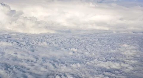 Fluffy clouds that looks as flat surface as seen from commercial airplane Foto stock