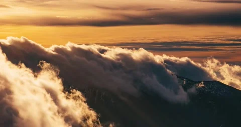 Fluffy clouds motion fast over alpine mountains in colorful nature golden sunset Video stock 229642249