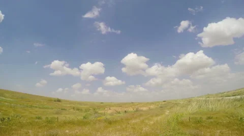 Fluffy clouds moving on the sky over dry grass in desert Stock Footage 48669846