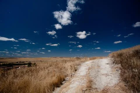 Fluffy clouds over dry fields Stock Photos