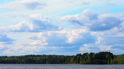 Fluffy Clouds over the Forest Lake, timelapse Stock Footage 33578409