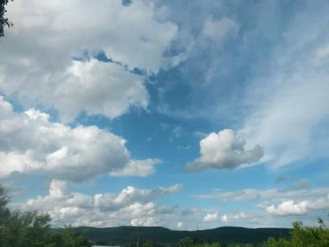 Fluffy clouds on the sky. cloudy day in the forest Stock Photos