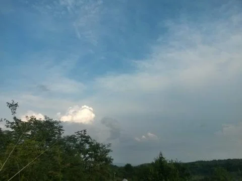 Fluffy clouds on the sky. cloudy day in the forest Stock Photos