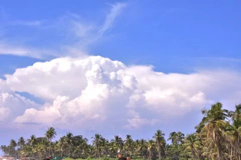 Fluffy clouds on top of a forest in Goa Stock Photos