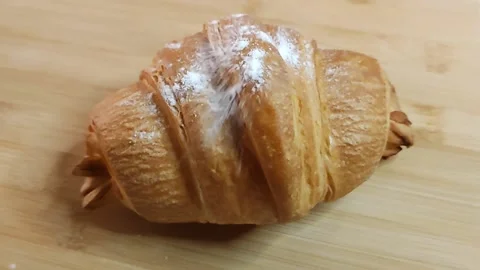 Fluffy croissant with crispy crust is sprinkled with powdered sugar 스톡 동영상 211351399