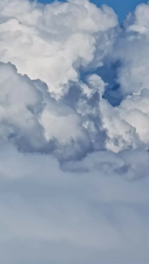 Fluffy Cumulus Clouds Against a Clear Blue Sky Видео 336679187