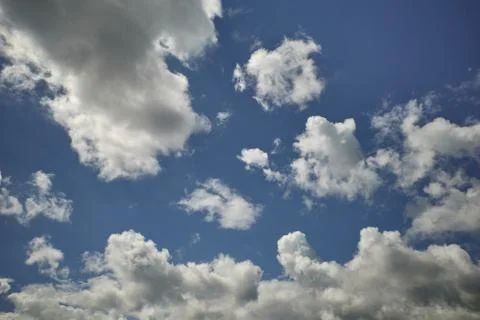 Fluffy cumulus clouds in the glorious blue sky Stock Photos