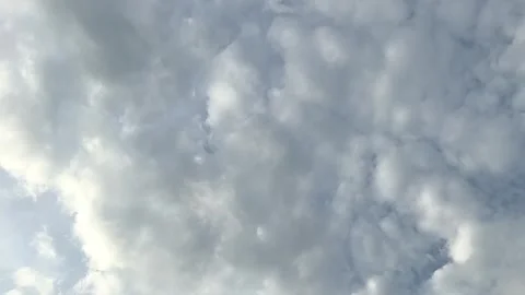 Fluffy cumulus clouds in pale blue evening sky Stock Footage 313475876