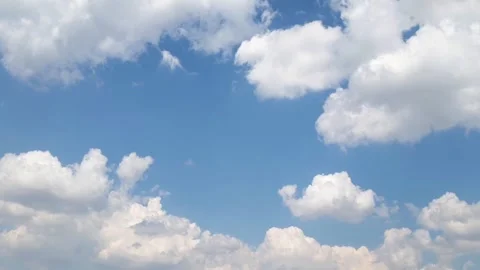 Fluffy cumulus clouds scattered across a vibrant blue sky. Stock Footage 295741979