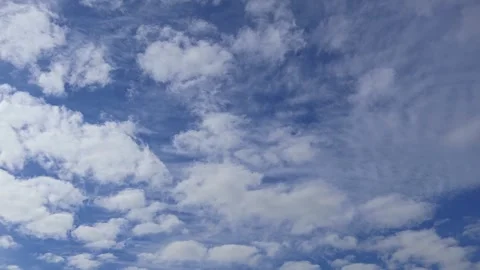 Fluffy cumulus white clouds are quickly floating across the blue sky Stock Footage 274635068