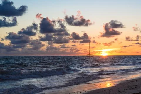 Fluffy dark clouds floating over turbulent ocean waters on sandy beach shore Foto stock
