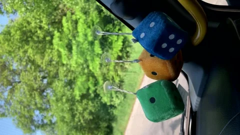 Fluffy dice dangle from the windshield. dice for dice.vertical screen Stock Footage 242628866