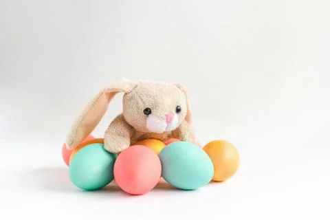 Fluffy Easter rabbit with colorful eggs on white background. Stock Photos