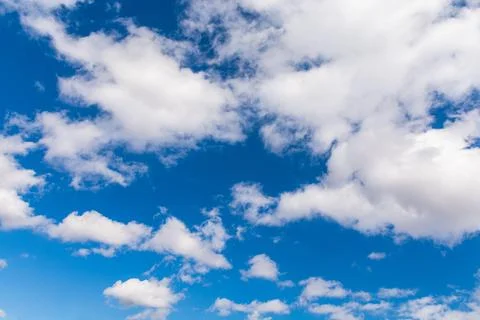 Fluffy heaping clouds on the blue sky in spring. Cirrus fluffy gentle clouds Stock Photos
