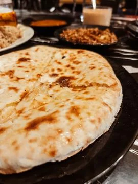 Fluffy nan bread served with condiments in a Pakistani restaurant. Stock Photos