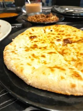 Fluffy nan bread served with condiments in a Pakistani restaurant. Stock Photos