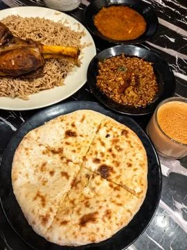 Fluffy nan bread served with condiments in a Pakistani restaurant. Stock Photos