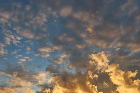 Fluffy orange clouds illuminated by the light coming from the setting sun. Pu Stock Photos