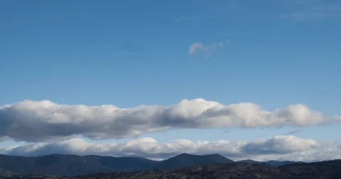 Fluffy Rolling Clouds Blue Sky Sunset Timelapse Over Mountains 4K Stock Footage 113933129