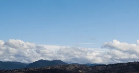 Fluffy Rolling Clouds Blue Sky Timelapse Over Mountains 4K Stock-Footage 113941345