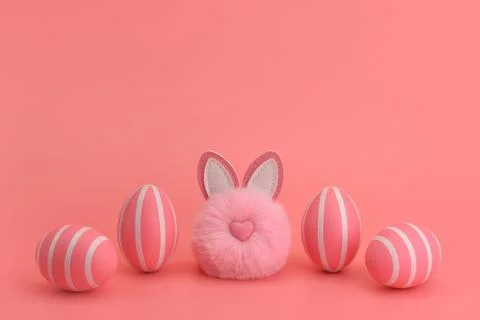 Fluffy round pink easter bunny in a row with pink striped eggs. Fotos de archivo