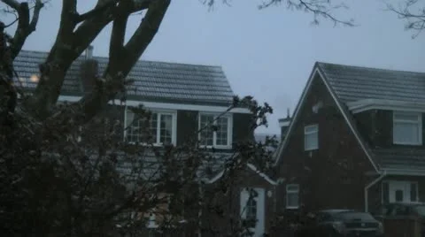 Fluffy snow flakes falling from grey sky in urban stree Stock Footage