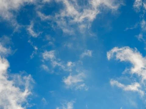 Fluffy soft clouds against a bright blue sky Stock Photos