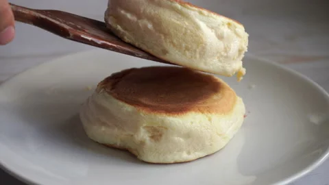 Fluffy souffle pancakes stack on the white plate pouring with the syrup Stock Footage 132509321