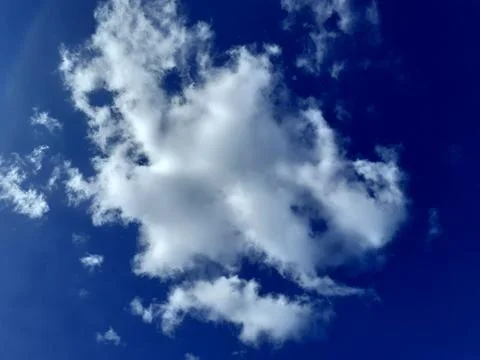 Fluffy White Cloud Drifting in Clear Blue Sky. A large cumulus cloud. Stock Photos