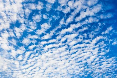 Fluffy white clouds against the blue sky. Nature background. Stock Photos