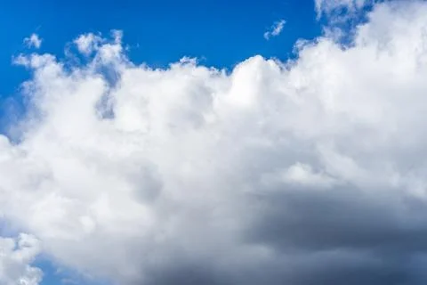 Fluffy white clouds against a bright, colorful blue sky Stock Photos