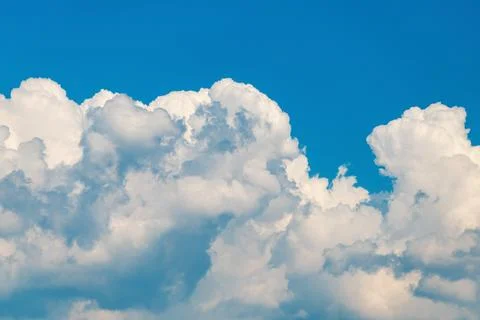 Fluffy white clouds against a bright blue sky Stock Photos