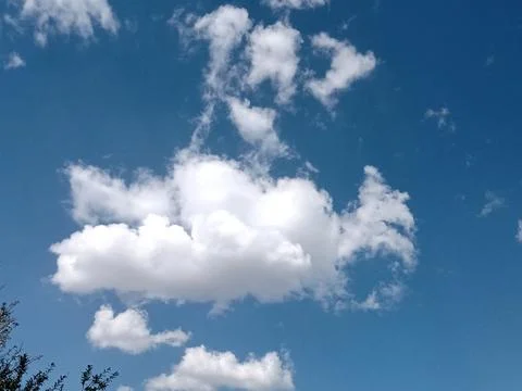Fluffy White Clouds Against a Bright Blue Sky 스톡 사진