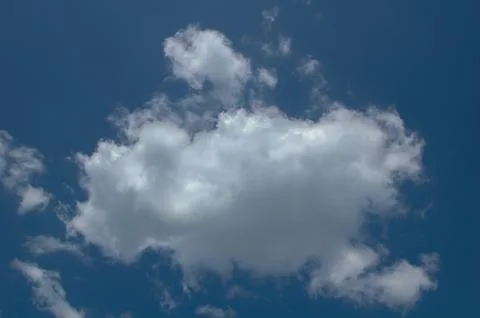 Fluffy White Clouds Against a Bright Blue Sky Stock Photos