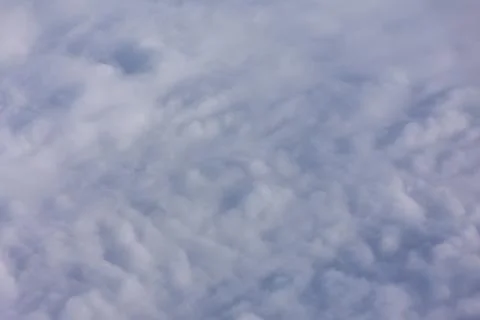 Fluffy, white clouds against a clear sky Stock Photos