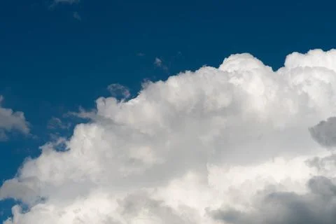 Fluffy white clouds against a deep blue sky Stock Photos