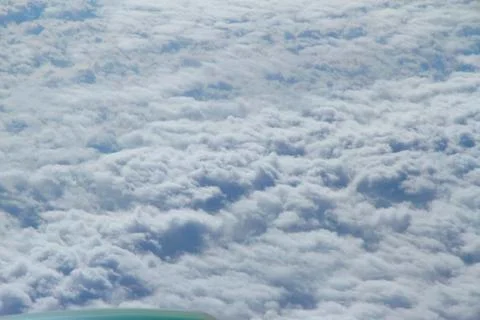 Fluffy white clouds from airplane window Stock Photos