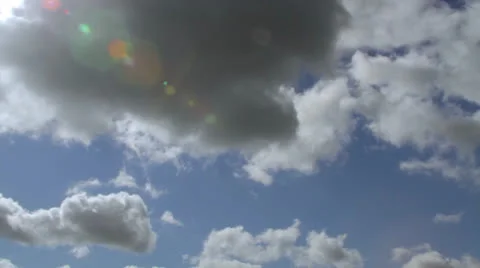 Fluffy White Clouds and Blue Sky with Sun Ray - Time-lapse Stock Footage 25333356
