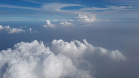 Fluffy white clouds and blue sky view from airplane Stock Footage 123751244