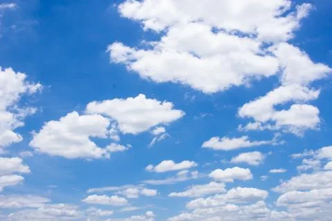 Fluffy white clouds and bright blue sky. Stock Photos