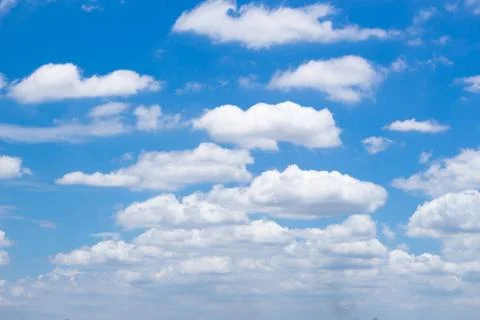 Fluffy white clouds and bright blue sky. Stock Photos