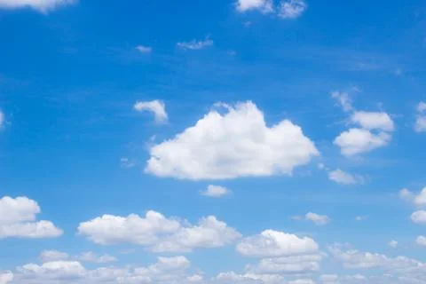 Fluffy white clouds and bright blue sky. Stock Photos