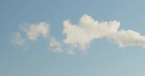 The Fluffy White Clouds are beautifully positioned in the Clear Blue Sky overhea Stock Footage 293593154