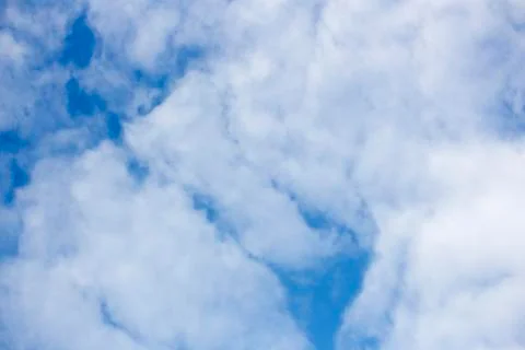 Fluffy white clouds in blue sky. Serene background and texture. With copy space. Stock Photos