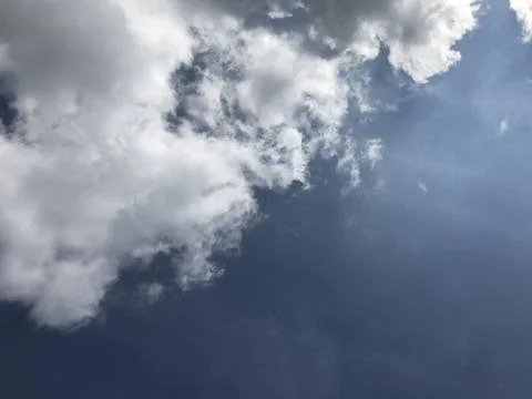 Fluffy white clouds in the blue sky with bright sunlight 写真素材