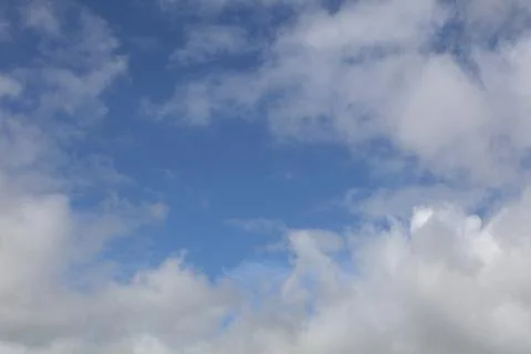Fluffy white clouds in a blue sky Stock Photos