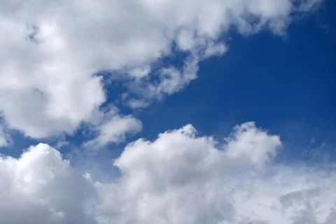 Fluffy white clouds on blue spring sky Stock Photos