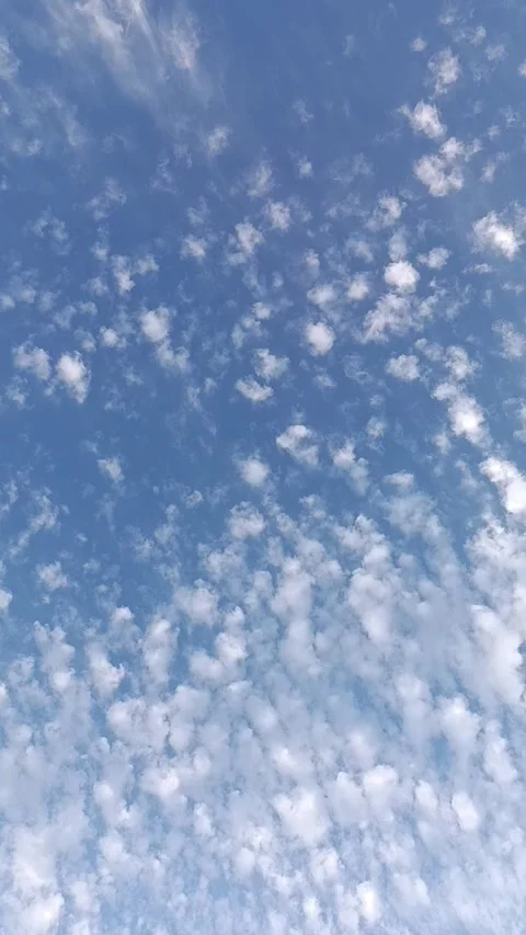 Fluffy white clouds in a bright blue sky, cinematic nature background. Stock Footage 323571738