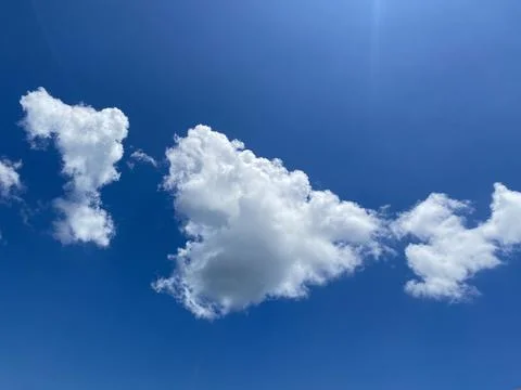 Fluffy White Clouds on Clear Blue Sky Stock Photos